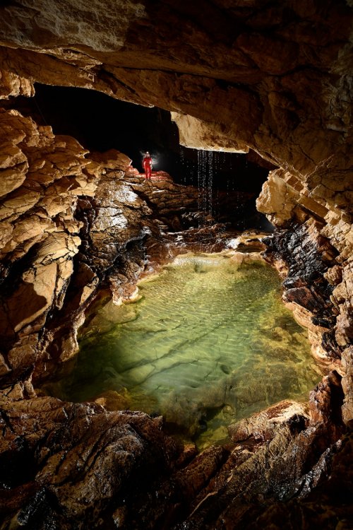 Photo Grotte de Vallorbe (Suisse) - Spéléo éclairant avec sa lampe Scurion  une cascatelle - Philippe Crochet - Photographe de la spéléologie et du  monde minéral